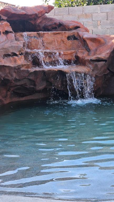 a waterfall in a pool of water with rocks at Aromas&Brumas Pousada in Brumadinho