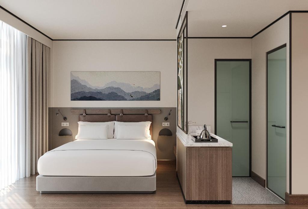 ein Schlafzimmer mit einem weißen Bett und einem Spiegel in der Unterkunft PureJoy Hotel City Center Phu Quoc in Phu Quoc