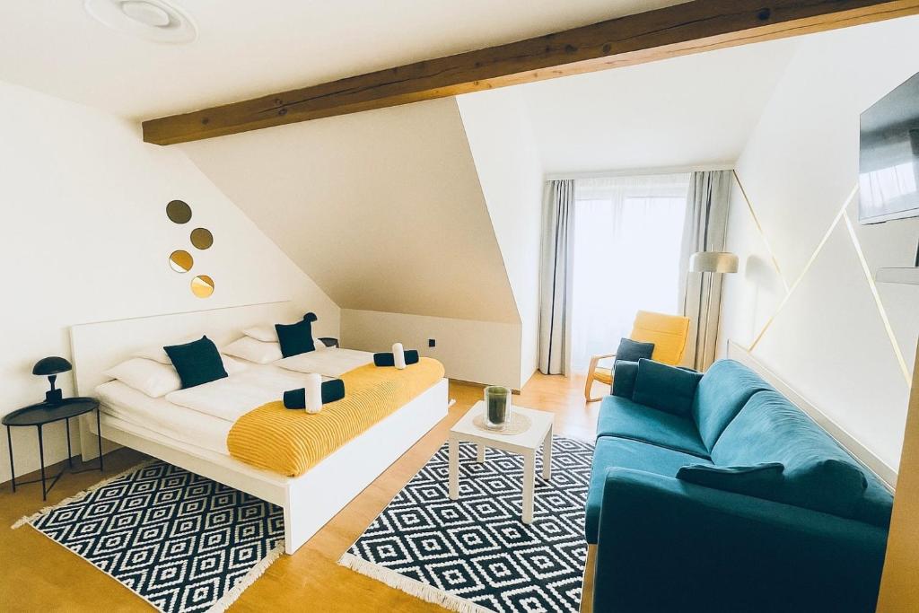 a bedroom with a bed and a couch at Alpesi Apartman Downtown in Sopron