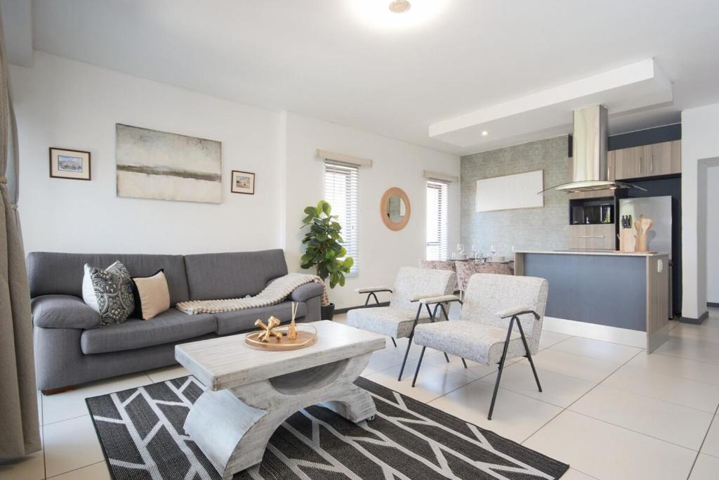 a living room with a couch and a table at The Atrium, Sandton Apartment in Johannesburg