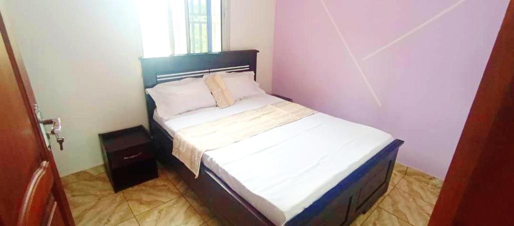 a small bedroom with a bed in a room at Mike's HOUSE in Yaoundé