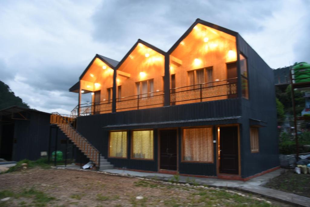 a house with a balcony on top of it at Shivanchal Homestay & Cottage in Uttarkāshi
