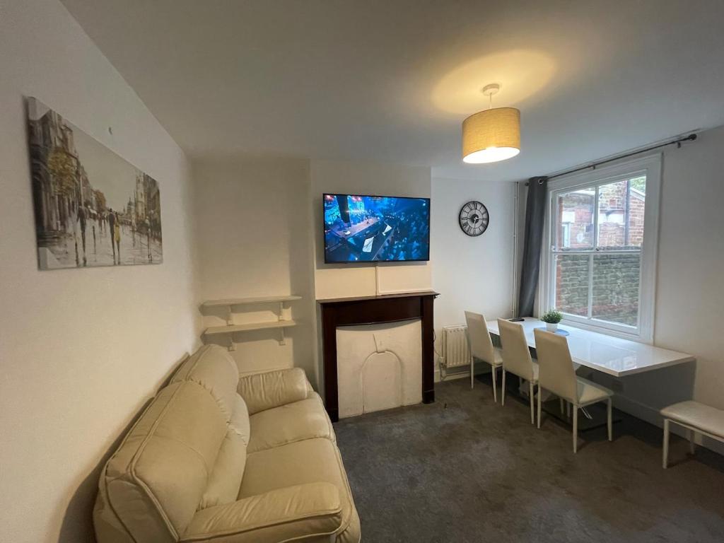 a living room with a couch and a table and a television at Livingwell Home in Gravesend
