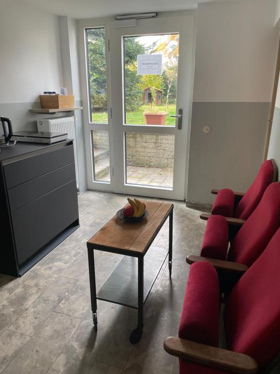 een woonkamer met een rode bank en een tafel bij Room!Moor in Schwarzenbach an der Saale