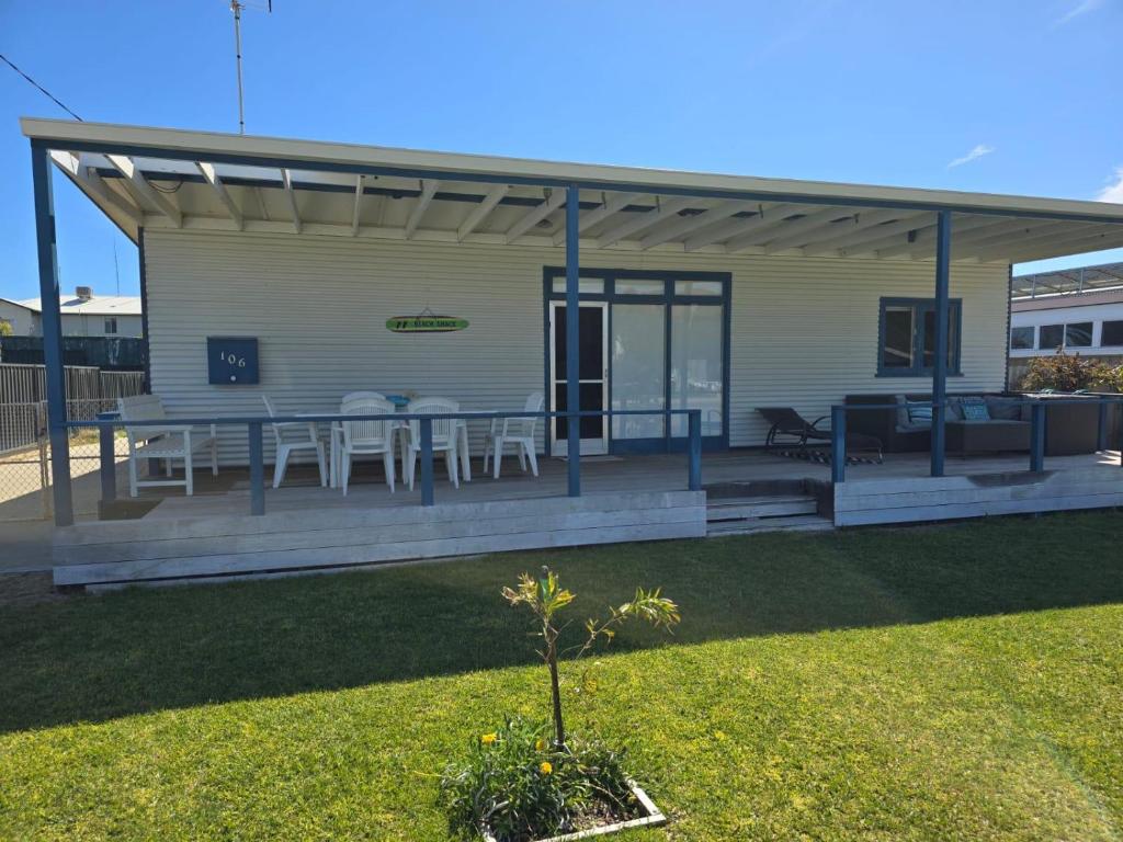 a house with a deck with tables and chairs at Lano Beach Shack in Lancelin