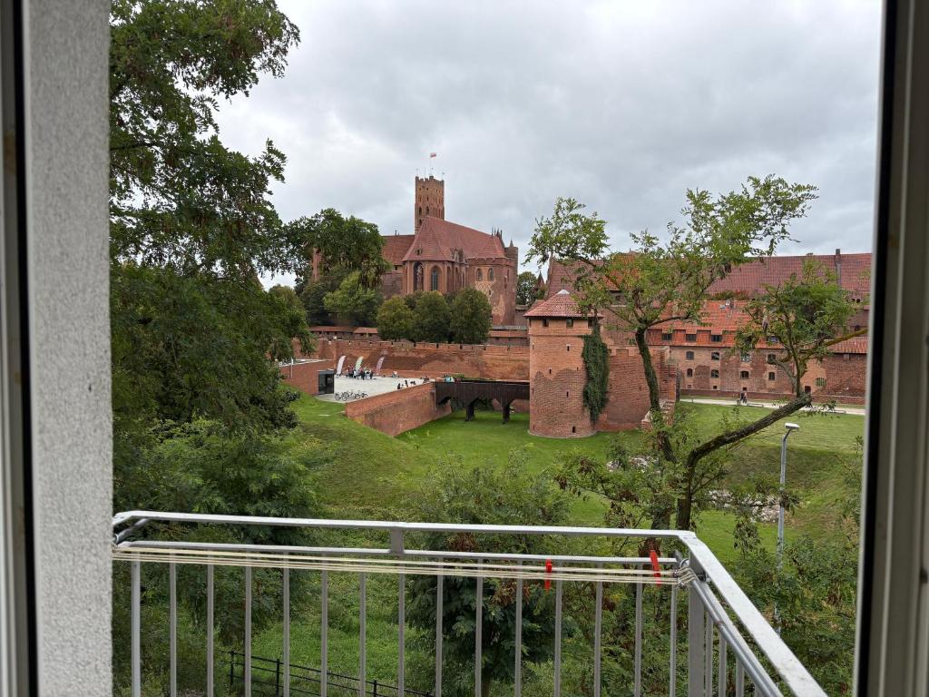 马尔堡Widok na Zamek的从大楼的阳台上可欣赏到城堡的景色