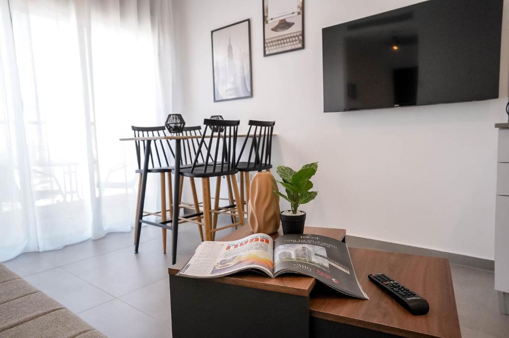 een woonkamer met een boek op een salontafel bij Red Sea Aurora - by G&P Suites in Eilat