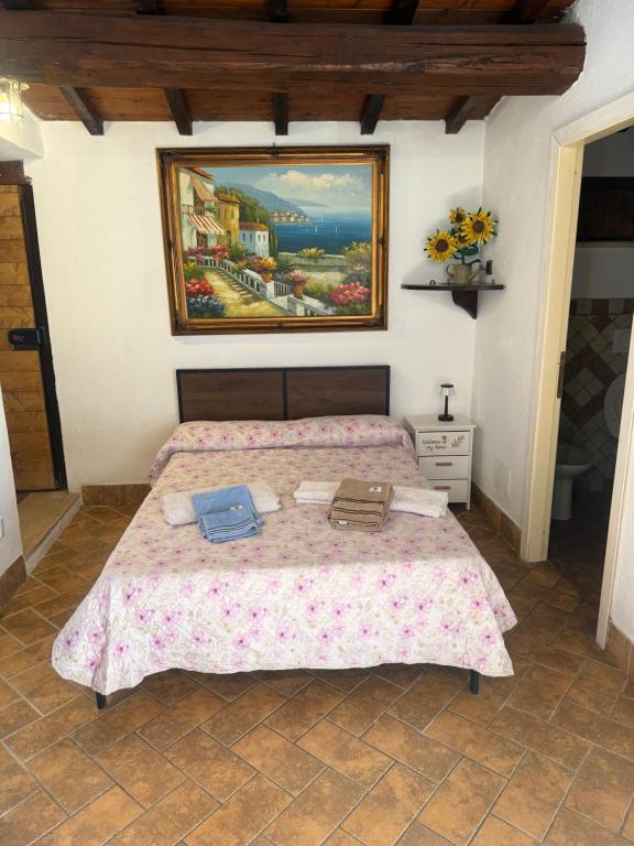 a bedroom with a bed with a painting on the wall at La Dimora in Formello