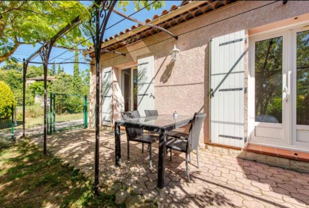 einen Tisch und eine Bank vor einem Haus in der Unterkunft logement indépendant avec jardinet in Bouc-Bel-Air