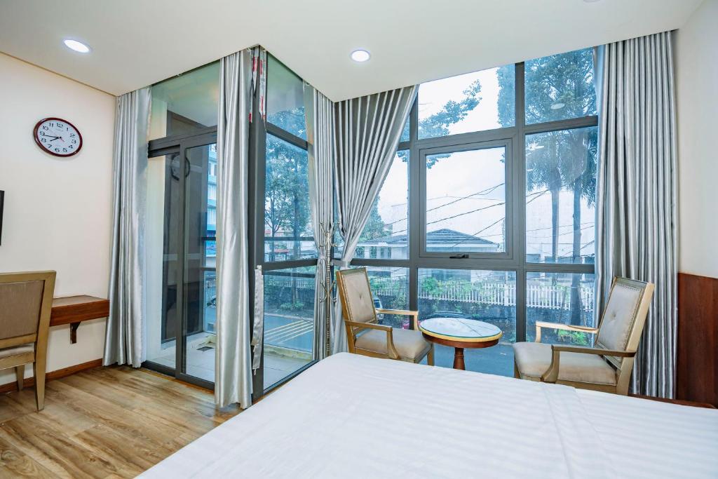 a bedroom with a bed and a table and chairs at Hotel Anh Đức 2 in Ga Phú Văn