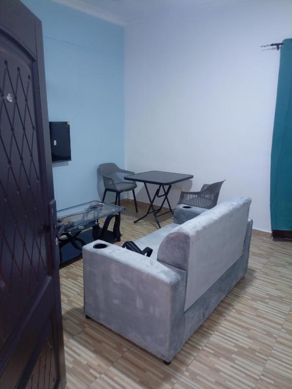 een woonkamer met een bank en een tafel bij Chambre et Salon in Agboogba