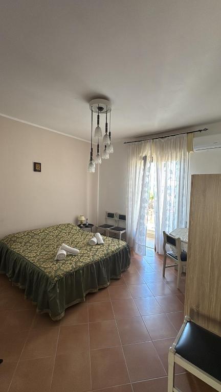 une chambre avec un lit, une table et des chaises dans l'établissement Casa Karmel, à Campofelice di Roccella