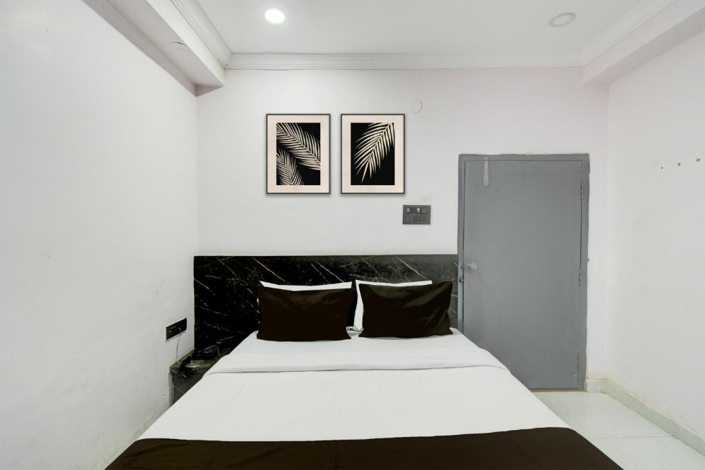 a bedroom with a white bed with two black pillows at Collection O Karmanghat Bus Terminal Hyderabad Formerly Hotel Chirag Stays in Hyderabad