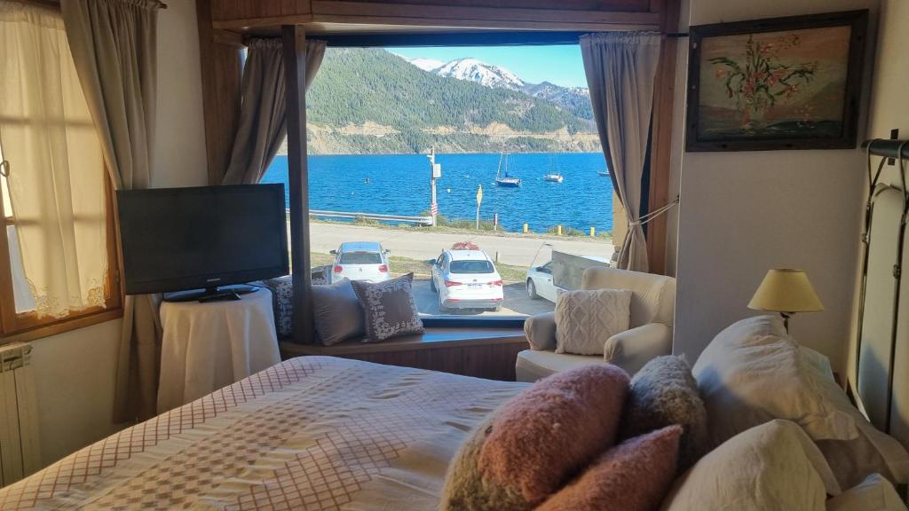 a bedroom with a bed and a view of the water at Cabañas frente al lago, lugar soñado in San Martín de los Andes