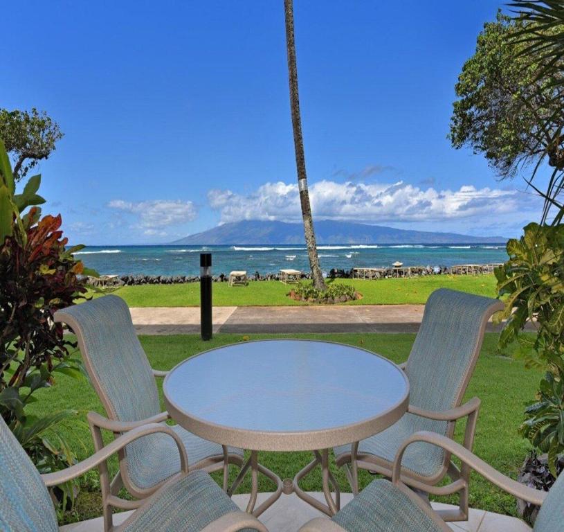a table and chairs with a view of the ocean at Kahana Reef 111 · KR 111 Renovated OceanFront Condo Romantic Get in Kahana