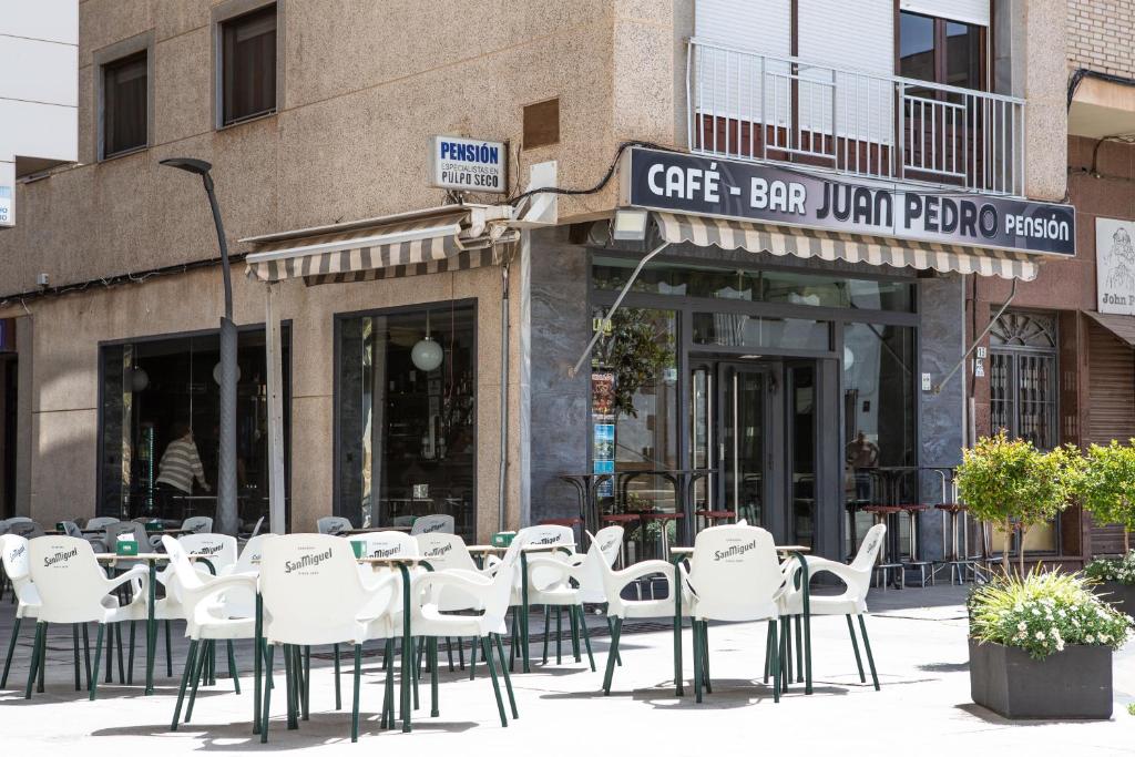 a group of tables and chairs in front of a store at Pensión Juan Pedro in Roquetas de Mar