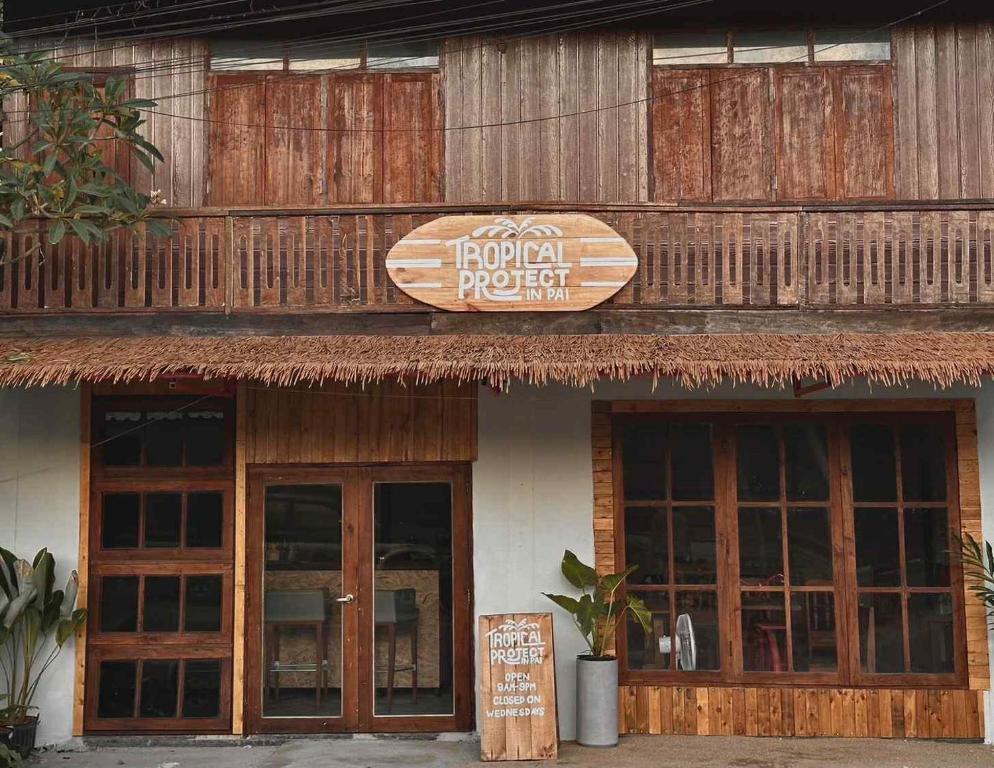 a hotel with a sign on the front of a building at Tropical Project in Pai in Pai