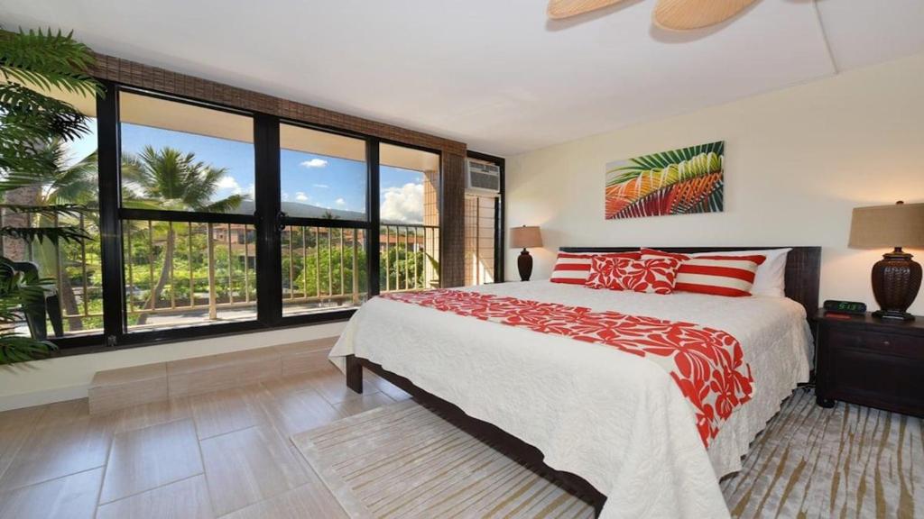 a bedroom with a bed and a large window at Kaleialoha 401 · KA 401 Spacious Studio w Mountain View Pool AC in Kahana