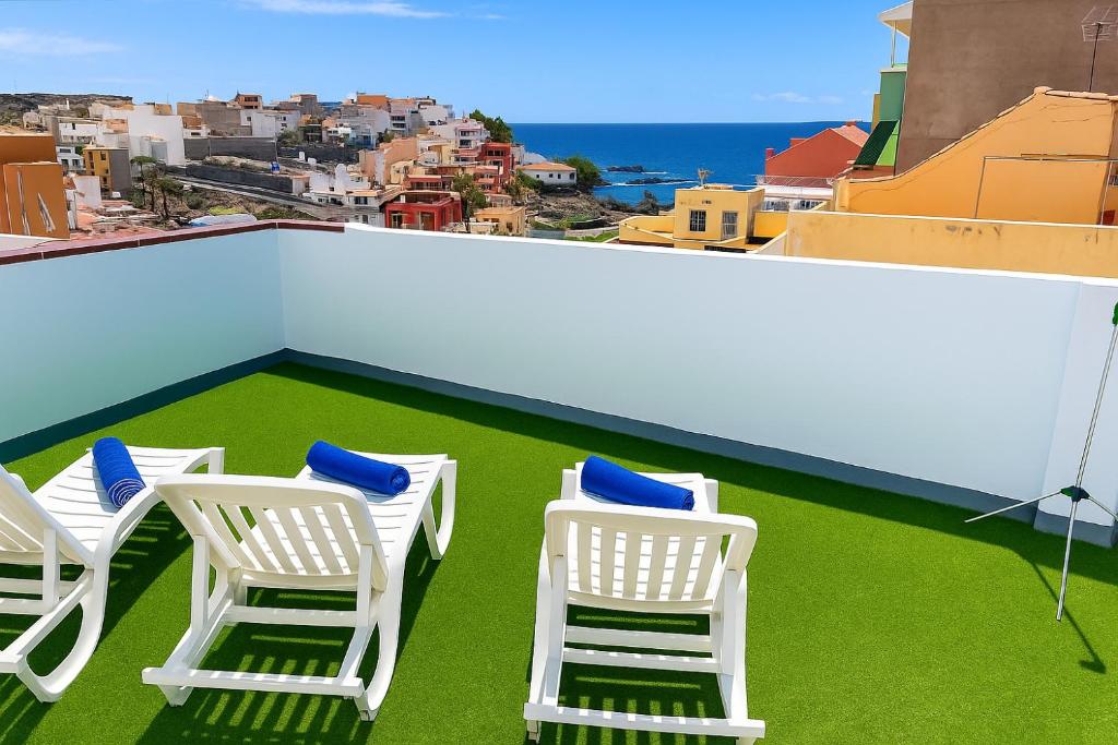 three chairs on a roof with a view of a city at La Cala de Alcalá Luxury in Alcalá