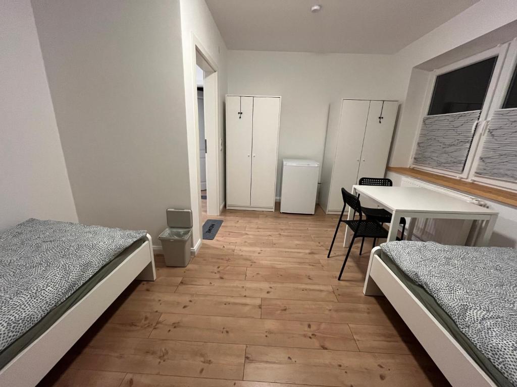 a room with two beds and a desk and a table at Rosengarten in Rosengarten