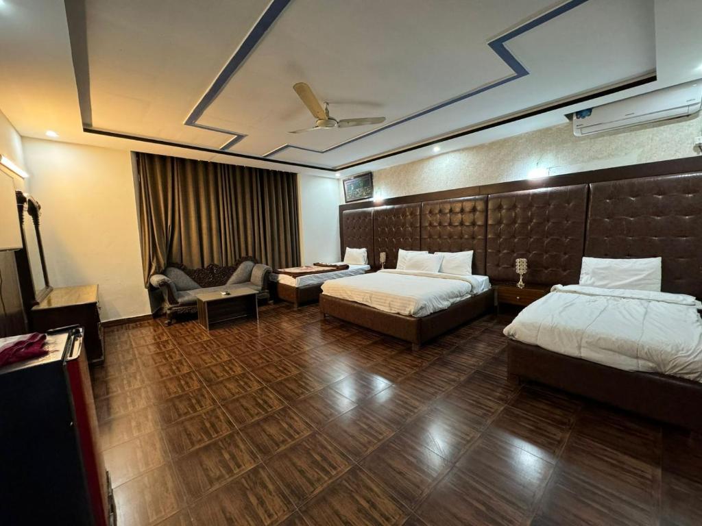 CasaNova Suites في اسلام اباد: غرفة فندقية تحتوي على سريرين وأريكة
