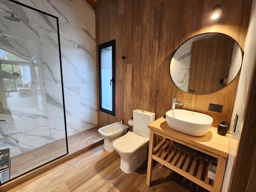 ein Badezimmer mit Toilette, Waschbecken und Spiegel in der Unterkunft Wenuk Patagonia in San Carlos de Bariloche