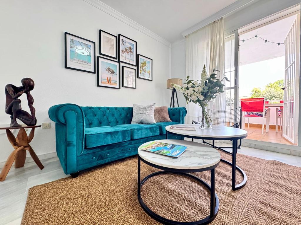 a living room with a blue couch and a table at Carihuela Playa Los Nidos 1 in Torremolinos