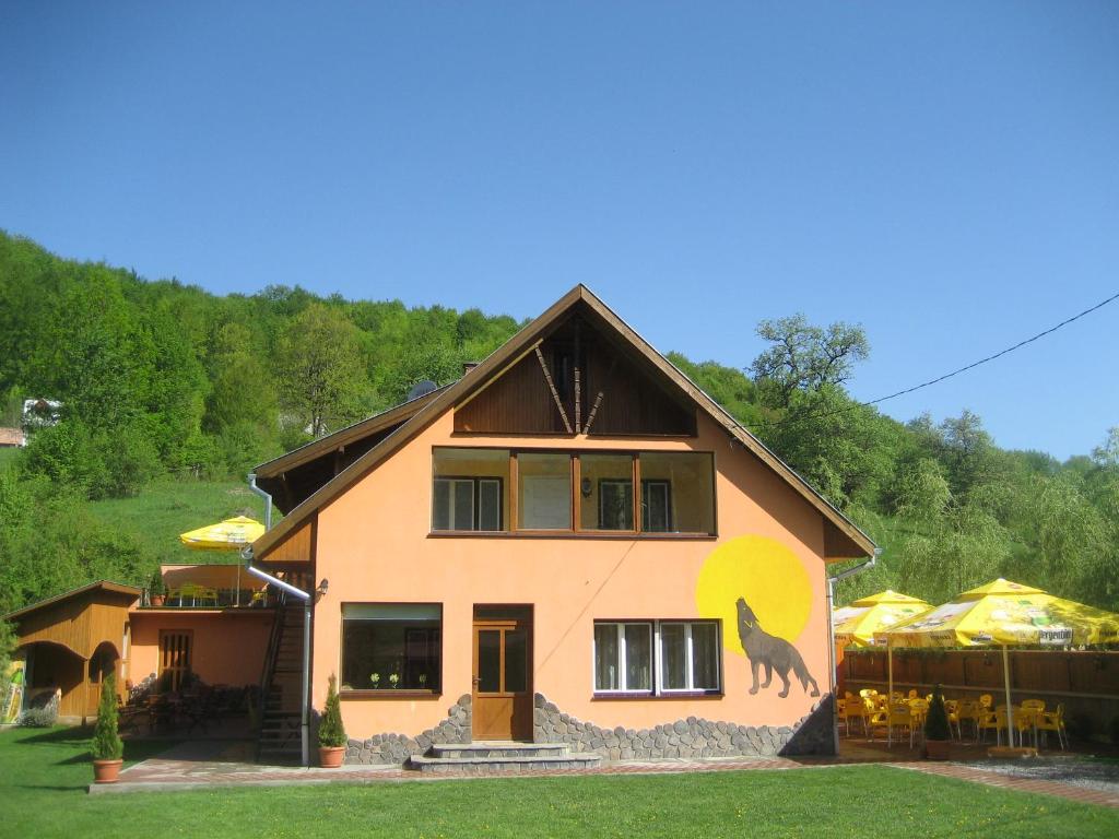 Ein Haus mit einem Wolf auf der Seite in der Unterkunft Pensiunea Colt Alb in Băile Homorod