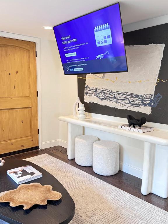 a living room with a white table with a tv on it at Farmhouse at Montaluce Winery-2 Restaurants- Fast WIFI-Free Park-Hike-Weddings in Dahlonega