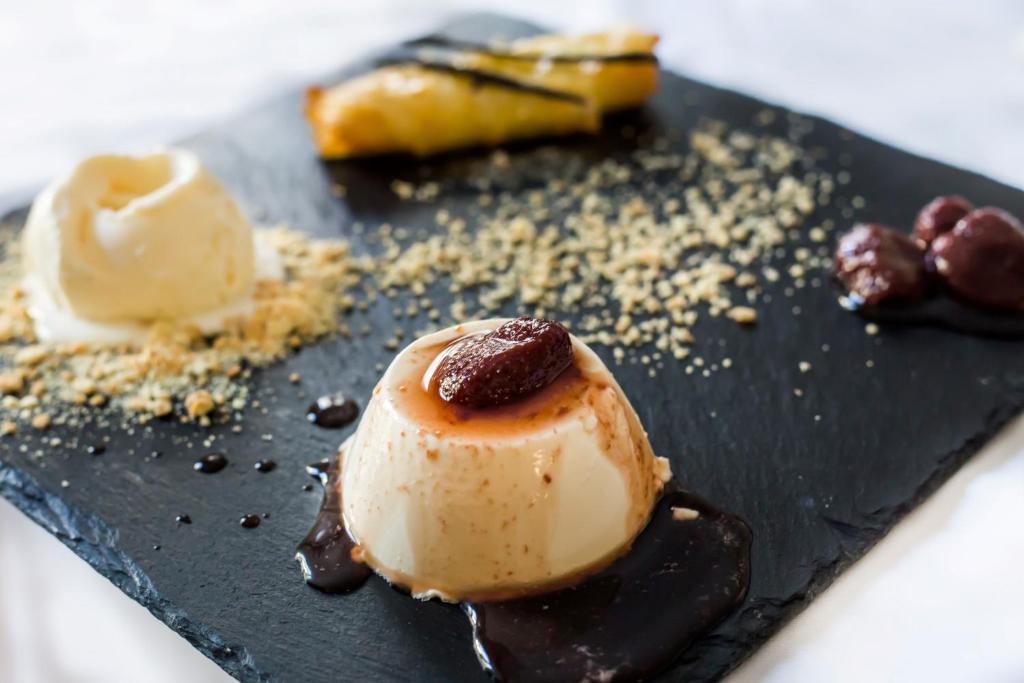 a black plate with a chocolate dessert on it at Thirides Beach Resort in Gythio