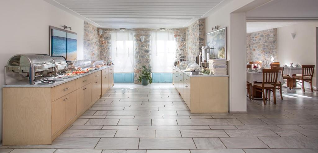 a kitchen with wooden cabinets and a dining room at Thirides Beach Resort in Gythio