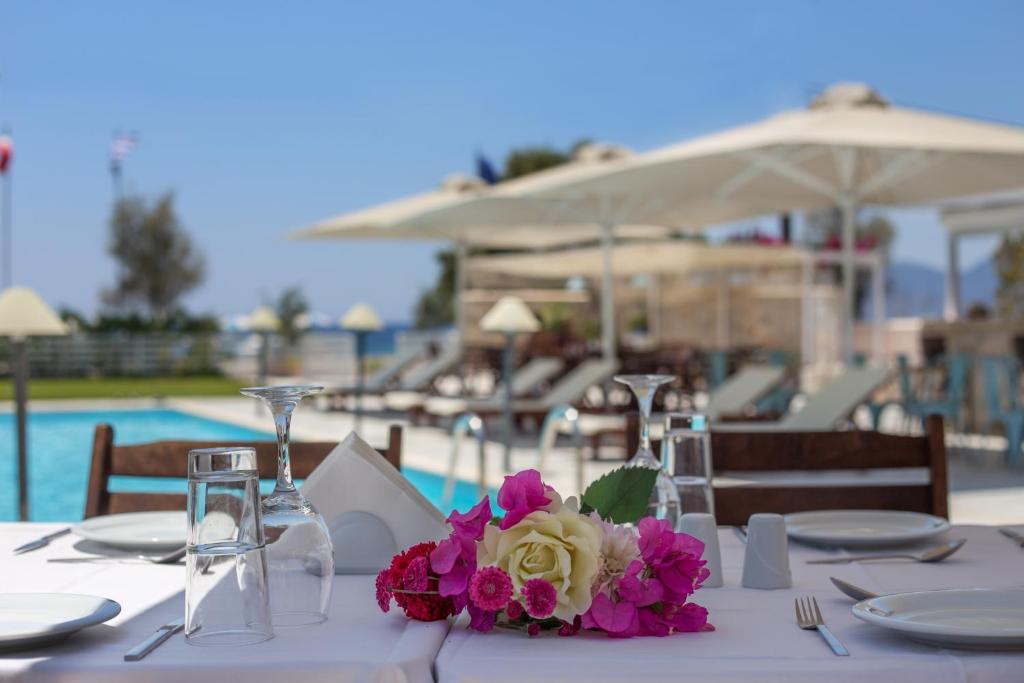 a table with a white table cloth and flowers on it at Thirides Beach Resort in Gythio