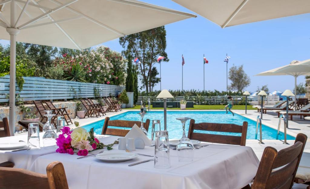 a table with a white table cloth and a pool at Thirides Beach Resort in Gythio