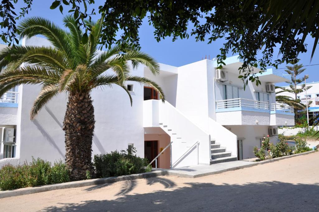 a palm tree in front of a white building at Your Second Home in Kefalos