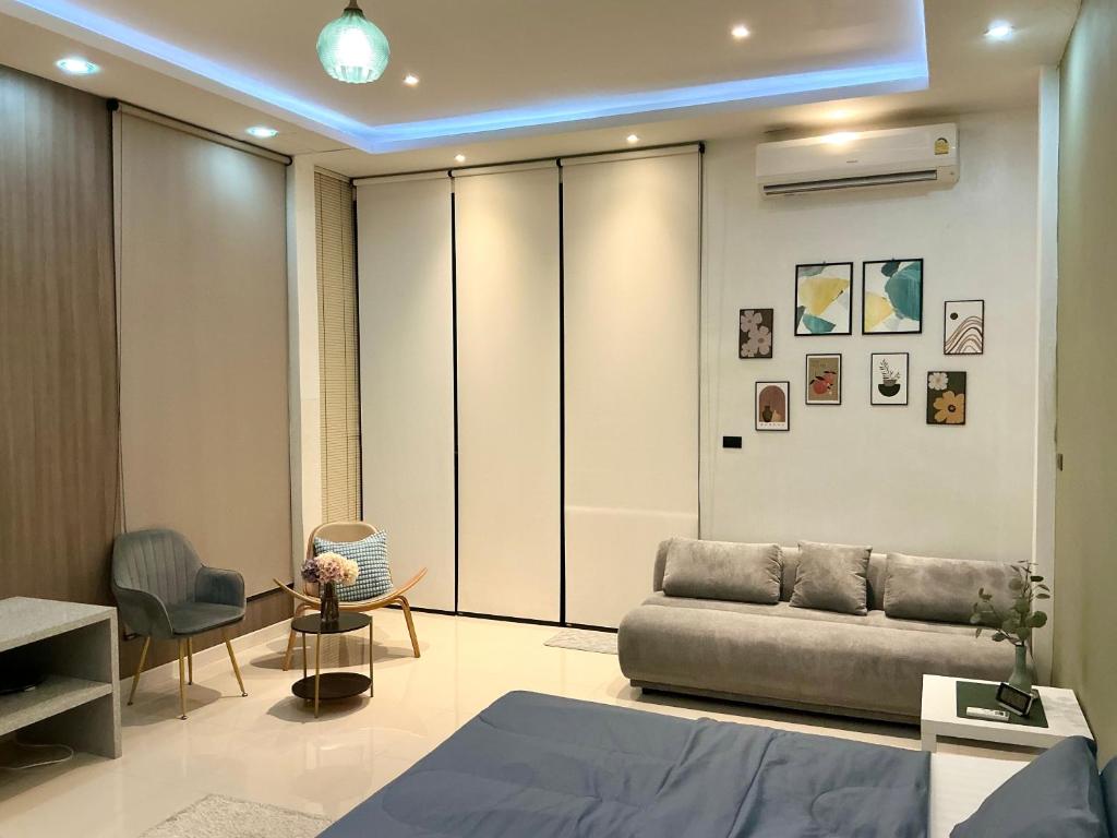 una sala de estar con un sofá y una silla en Ellie House Phuket Old Town, en Ban Rangeng
