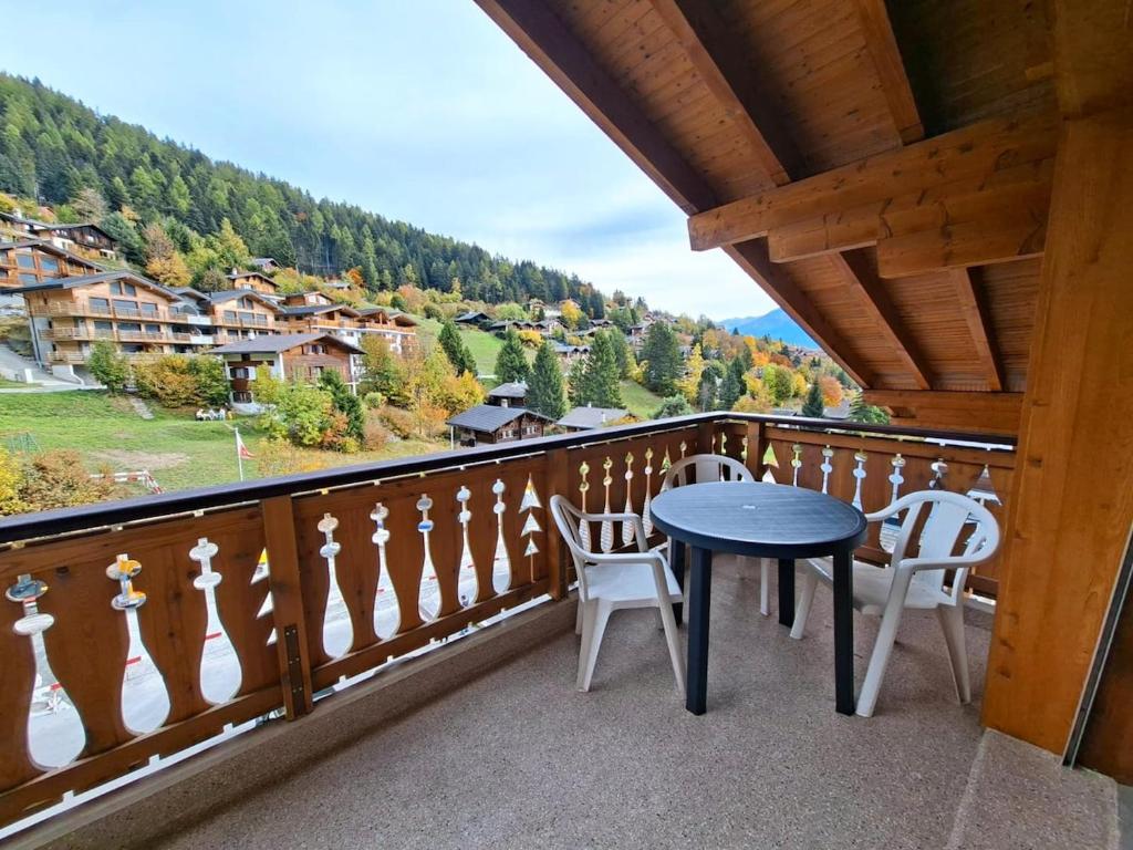 a table and chairs on a balcony with a view at Chez Cle'Montagne in Ovronnaz
