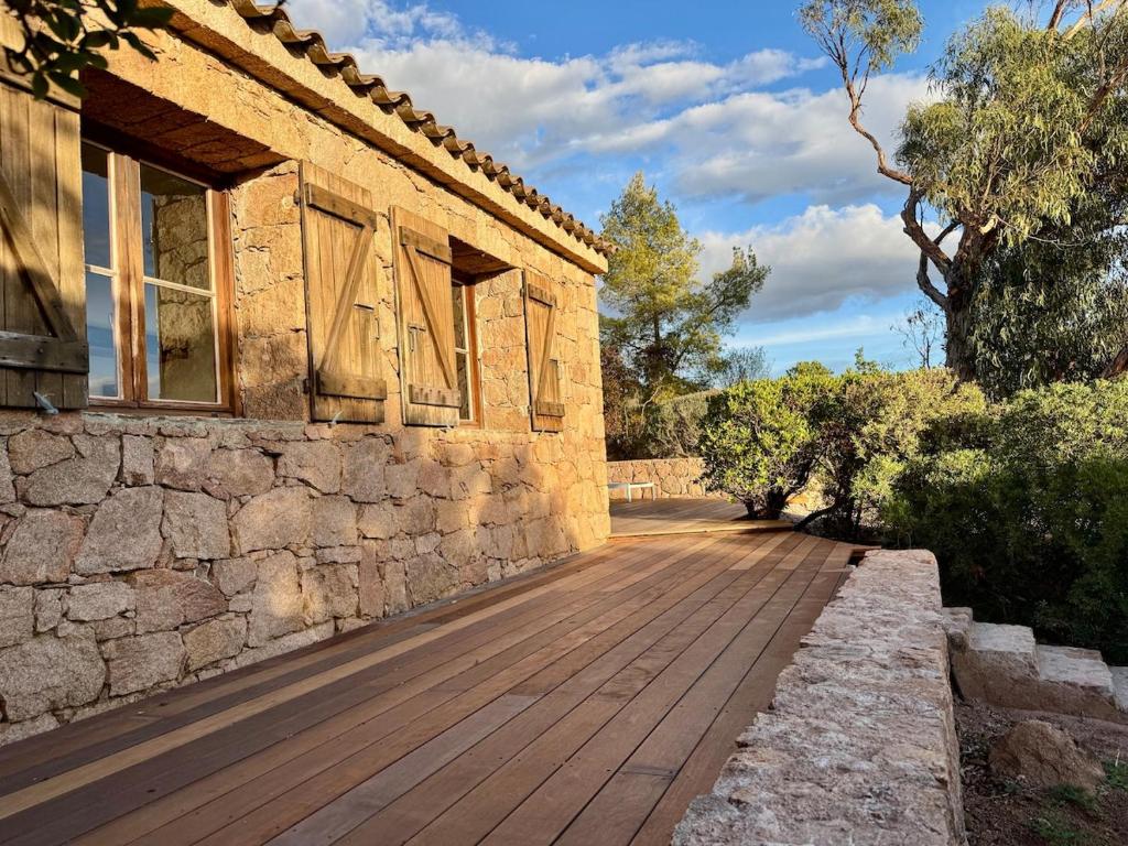 a wooden walkway next to a stone building at Casetta di Asciaghju in Porto-Vecchio