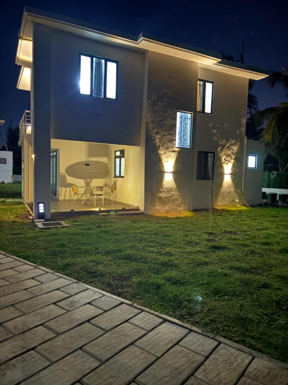 Una casa con una mesa en el patio por la noche. en Cool Breeze Villa No 2, en Grand Baie