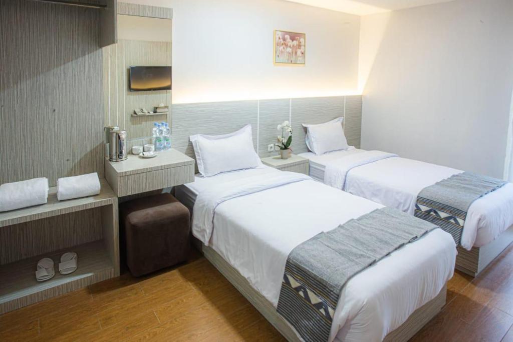 a hotel room with two beds in a room at parade inn kendari in Pipulu