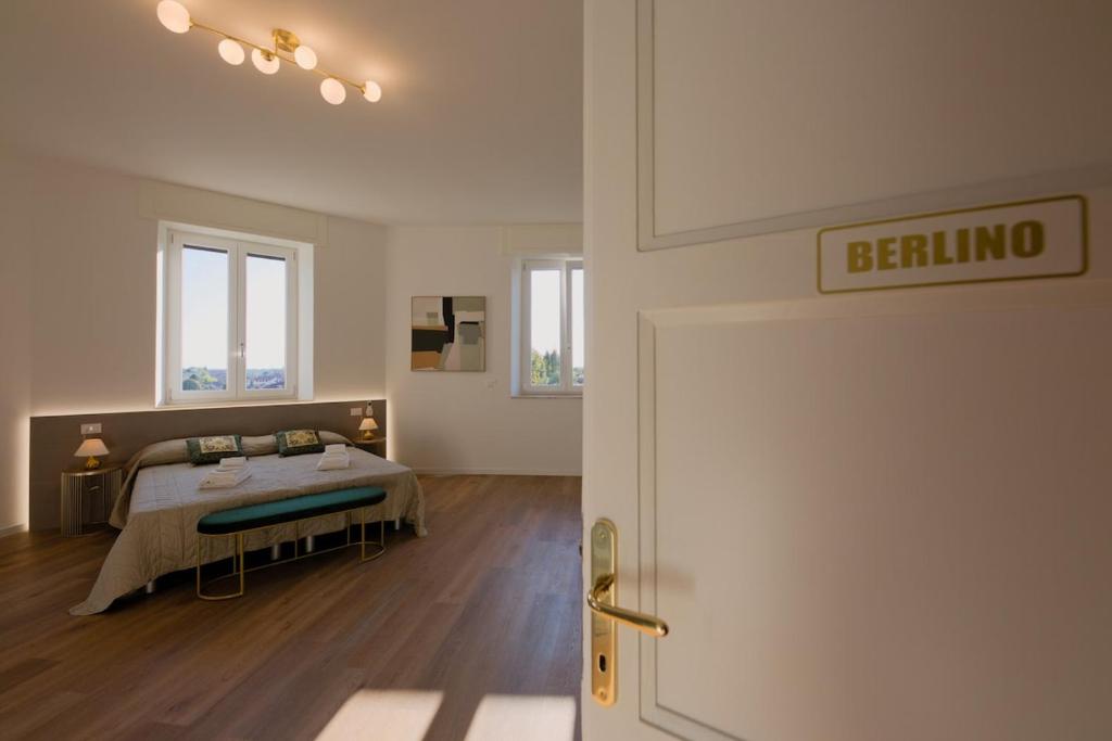 a bedroom with a bed and a door with a beduna sign at Camera Berlino - La Casa di Carta Affittacamere in Udine