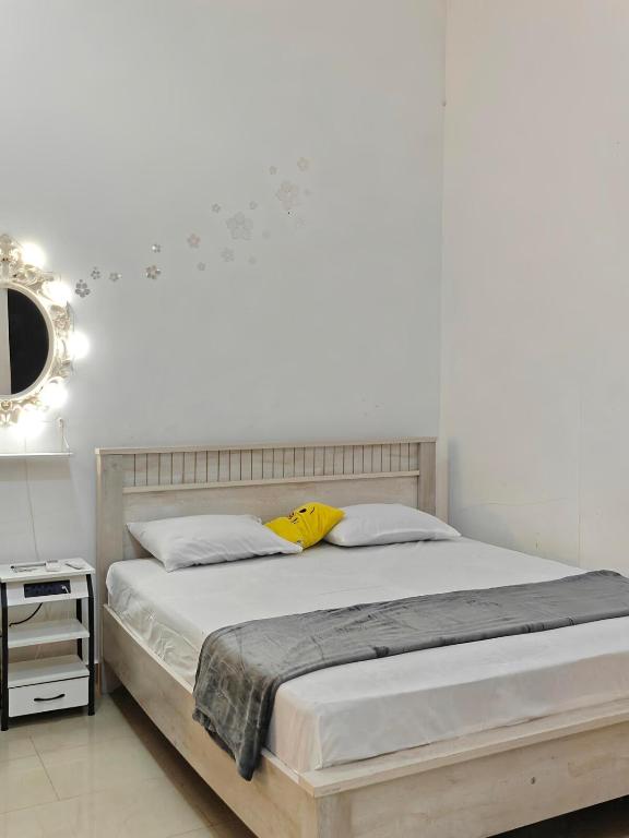 Un dormitorio blanco con una cama grande y un espejo. en Studio Available in MBZ Abu Dhabi, en Abu Dabi