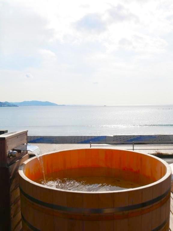 a large barrel with water in it next to the ocean at mokumoku海sakanoshita in Kamakura