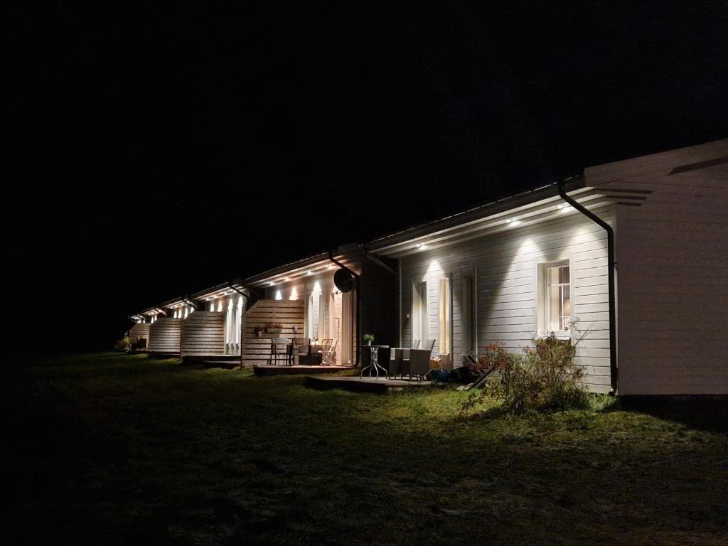 a row of houses lit up at night at ArcticStay Economy in Pajala