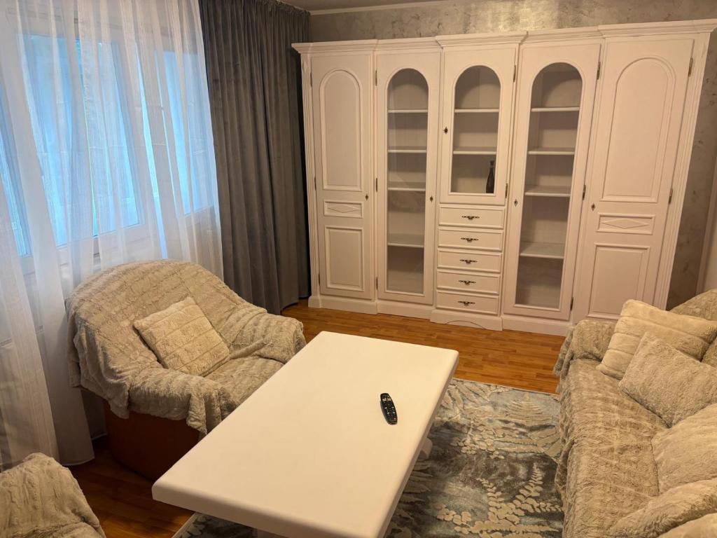 a living room with a table and a white cabinet at Apartament Lux 3 camere in Roman