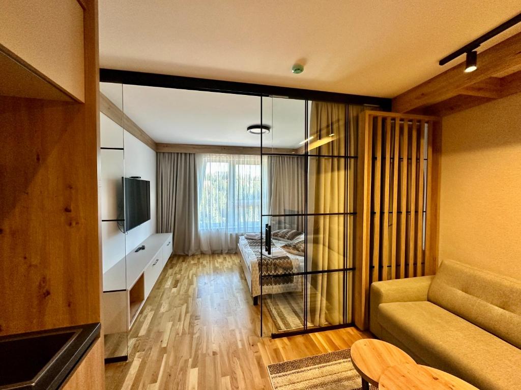 a living room with a couch and a television at Apartman A55 Aparthotel Vučko privatni apartman in Jahorina