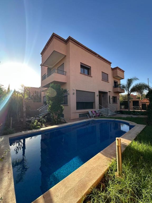 a house with a swimming pool in front of a house at Villa Amroth in Marrakech