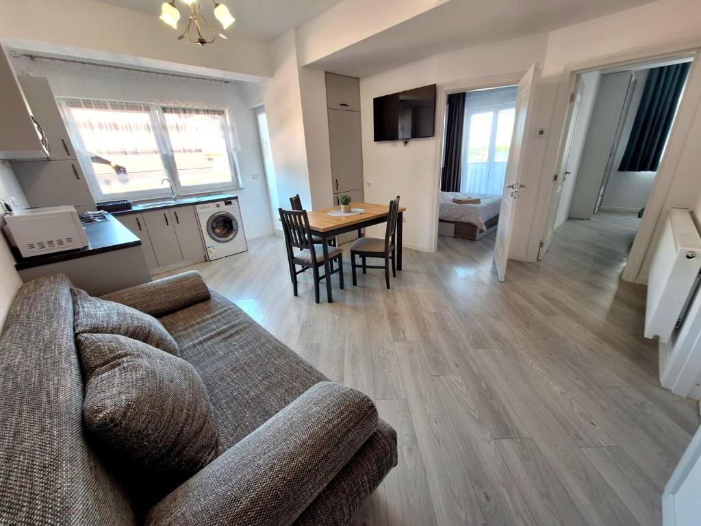 ein Wohnzimmer mit Sofa und Tisch in der Unterkunft Central 3 Rooms Retreat - Rădăuți in Rădăuţi