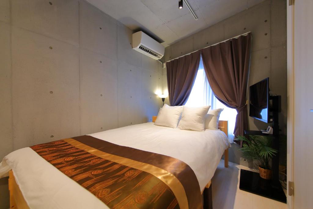a bedroom with a large bed and a window at Tokyo Time Traveler 駅徒歩5分 暮らすように泊まれるホテル in Tokyo