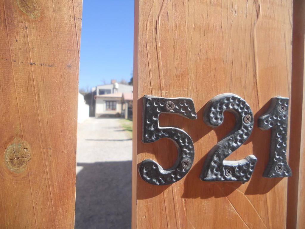 a house number on the side of a wooden door at La Estancia in Maimará