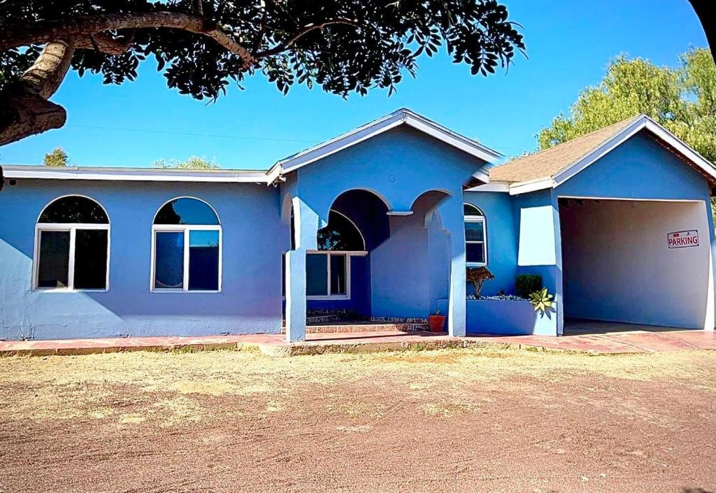 a blue house with a garage at San Quintin Casa Skov in Los Pinos